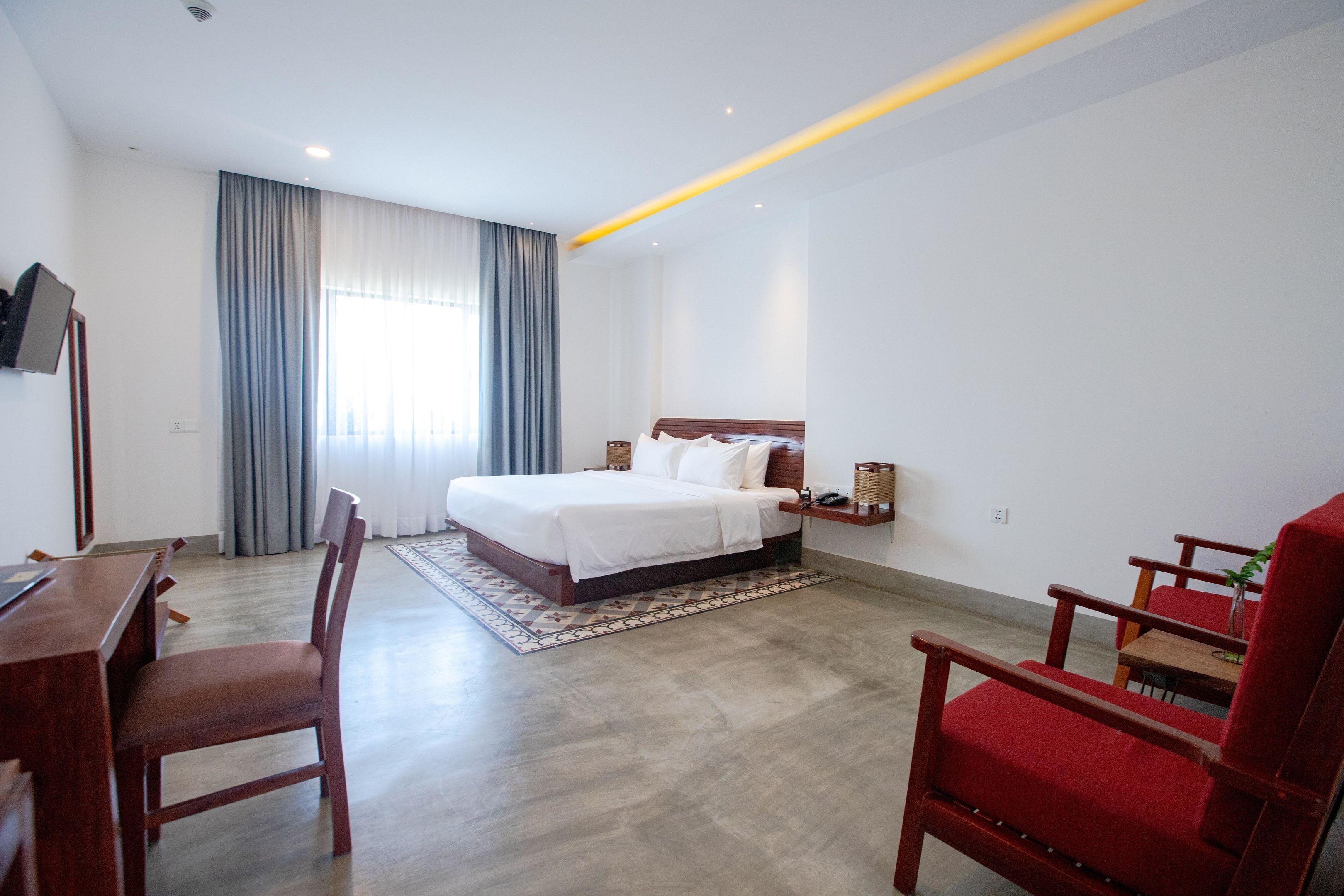 Ein Hotelzimmer mit einem Bett, einem Schreibtisch und zwei Stühlen.