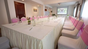 A conference room with a long table, chairs, and a projector screen. - DACO Hotel (Siem Reap)
