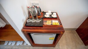 Ein kleiner Holztisch mit einer Kaffeemaschine, Tassen und Beilagen.