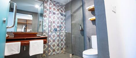 Une salle de bain moderne avec une douche à parois de verre, des toilettes et un lavabo avec un miroir.