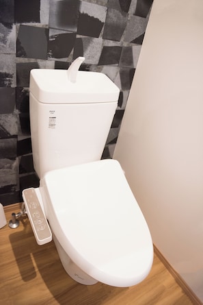 A modern toilet with a control panel and a lid. - tycq (Osaka)