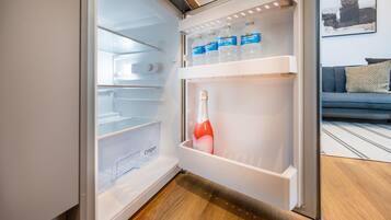 An open refrigerator with water bottles and a bottle of water.