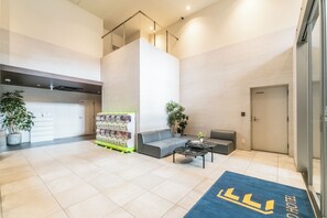 A modern hotel lobby with a reception desk, seating area, and a staircase. - Eslead Hotel Osaka Nipponbashi (Osaka)