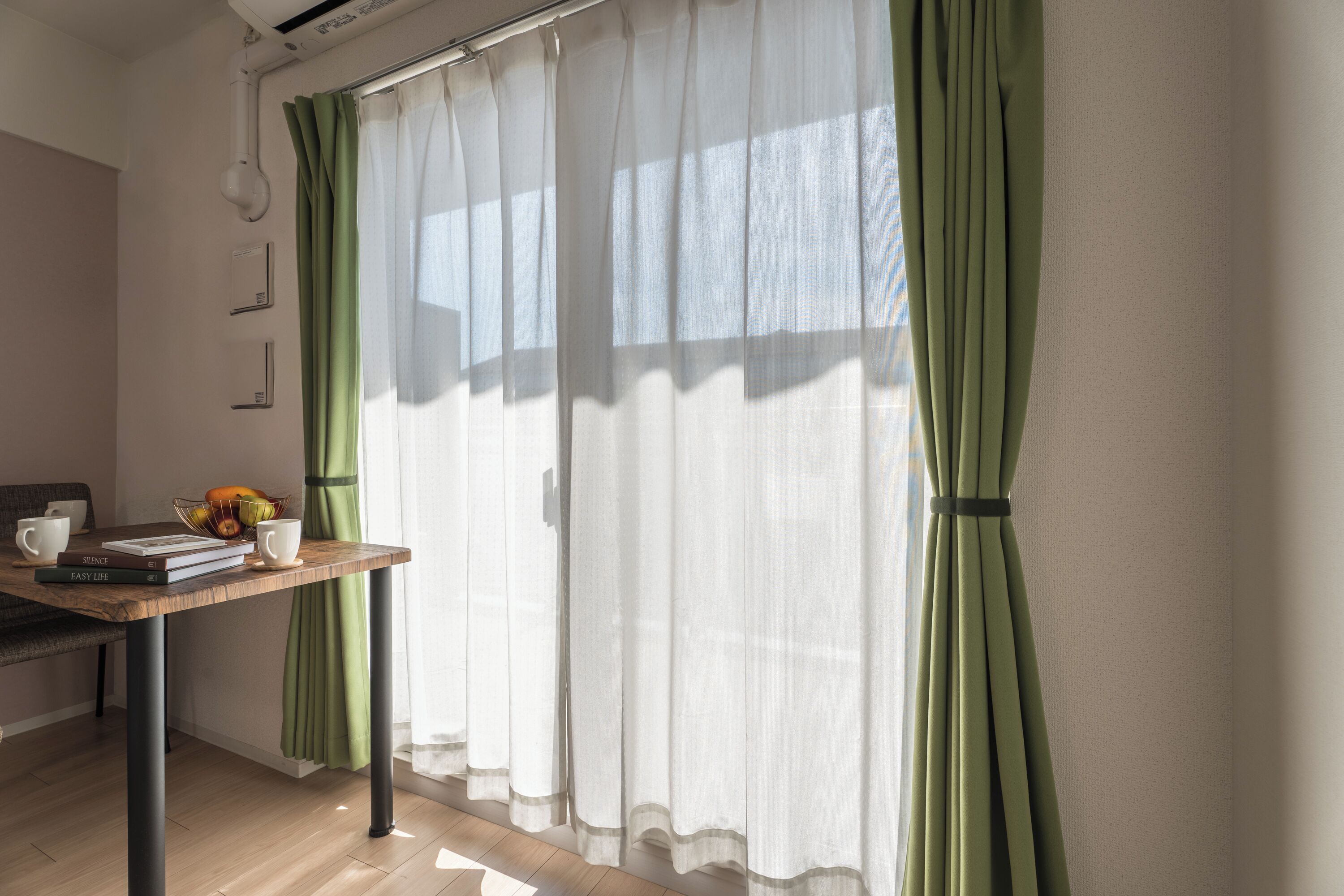 Una habitación con una mesa de madera, una taza blanca y un cuenco con fruta.