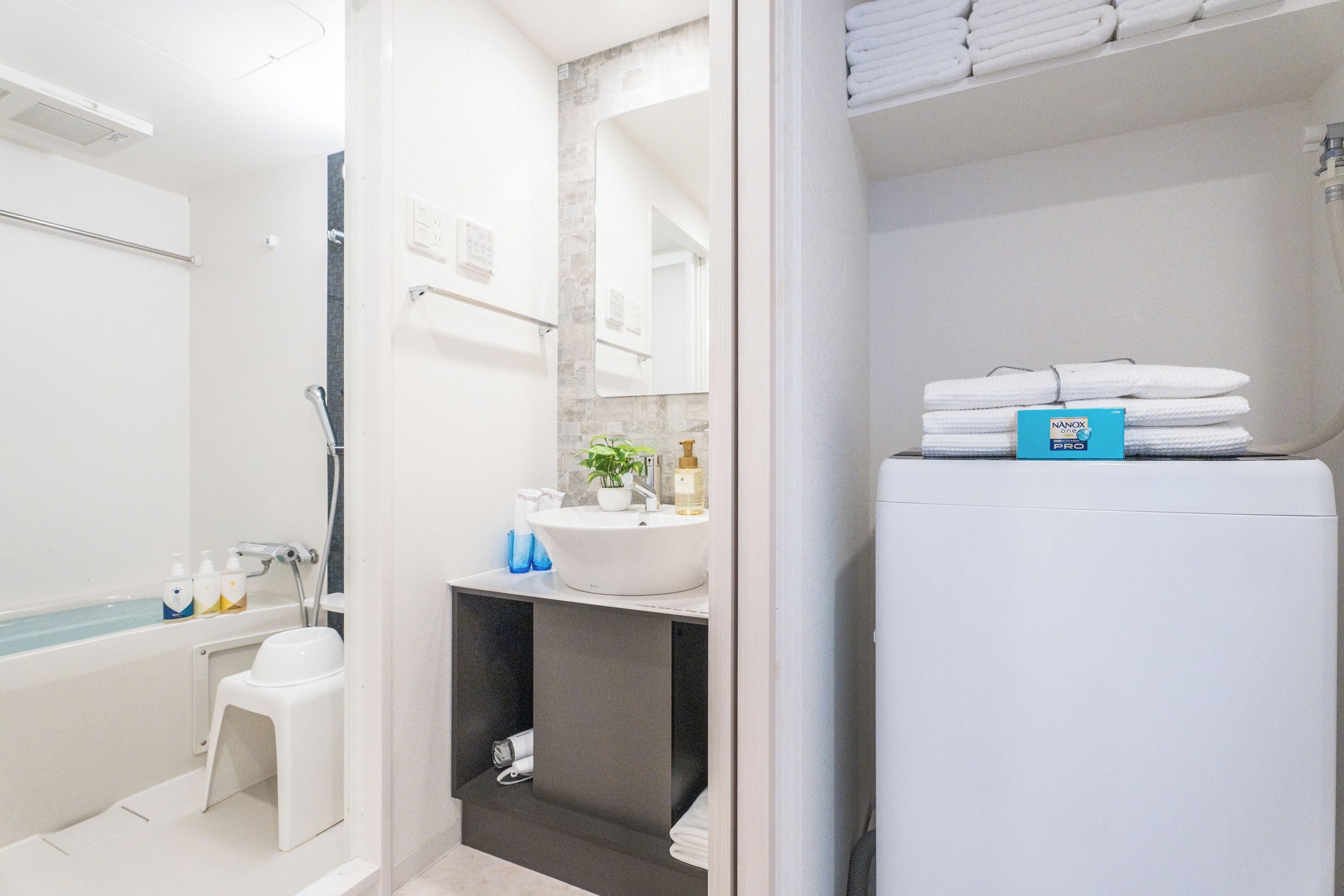 A bathroom with a bathtub, a sink, a mirror, and a towel rack.