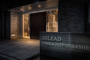 A building entrance with a sign reading 'ESLEAD OSAKA NIPPONBASHI'.