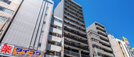 A multi-story building with commercial signage on the ground floor, including a pharmacy and a telecommunications company.