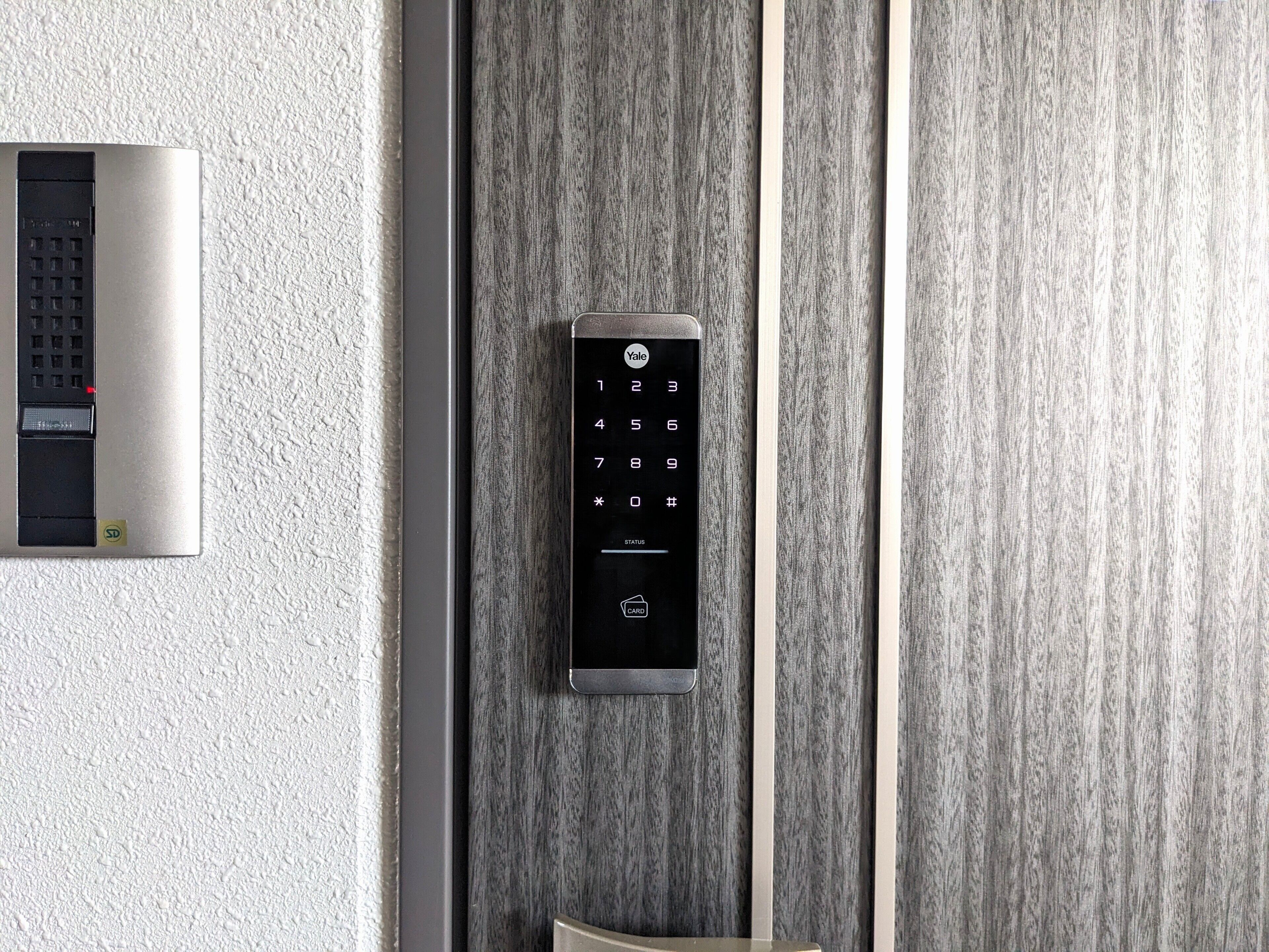 Un ascensor moderno con teclado y lector de tarjetas, instalado en una pared con textura.