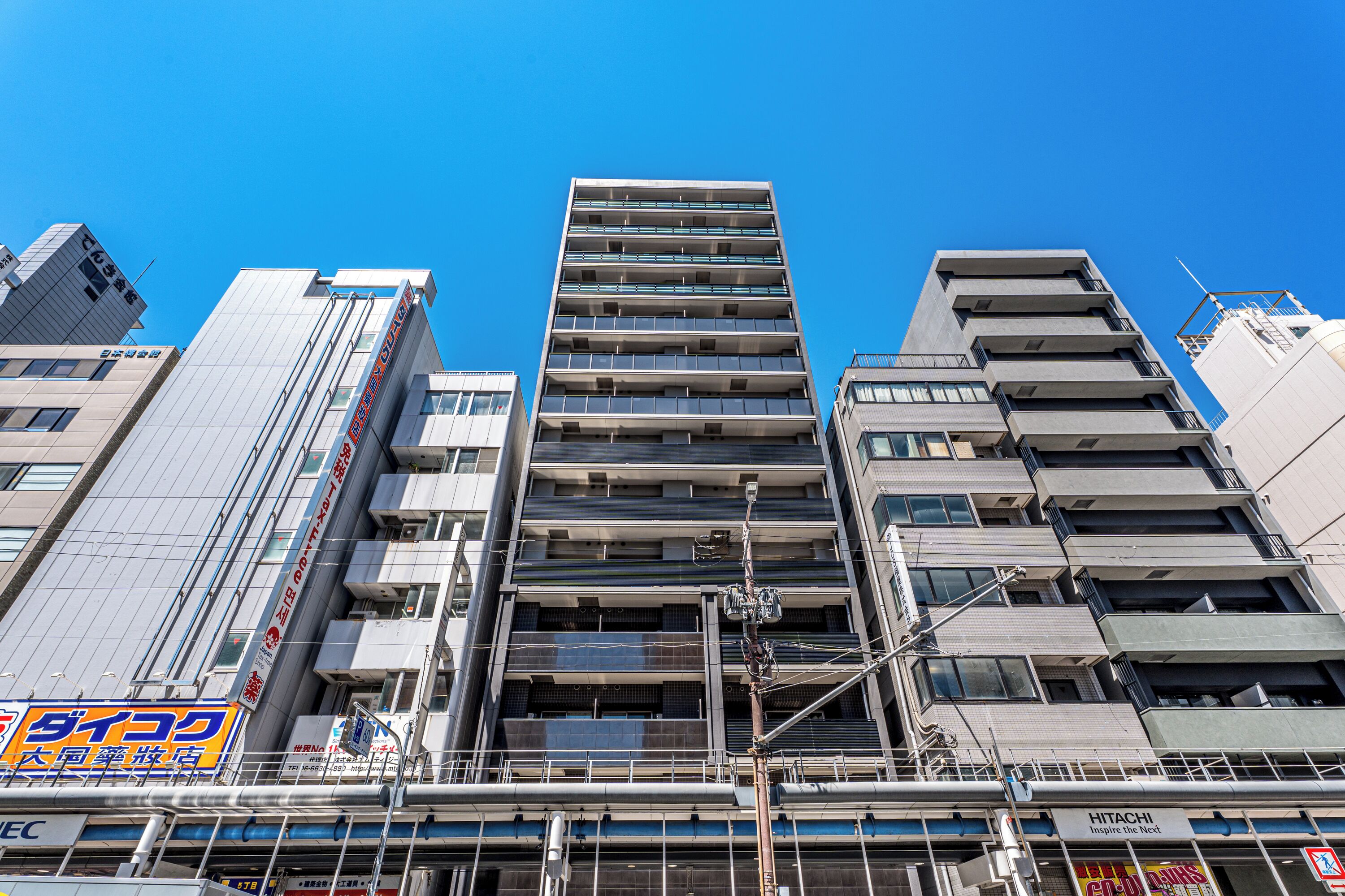 Un immeuble à plusieurs étages doté d’un noyau central, entouré d’autres bâtiments.
