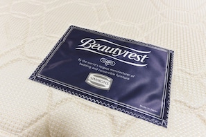 Un emballage de matelas Beautyrest posé sur une surface en tissu texturé.