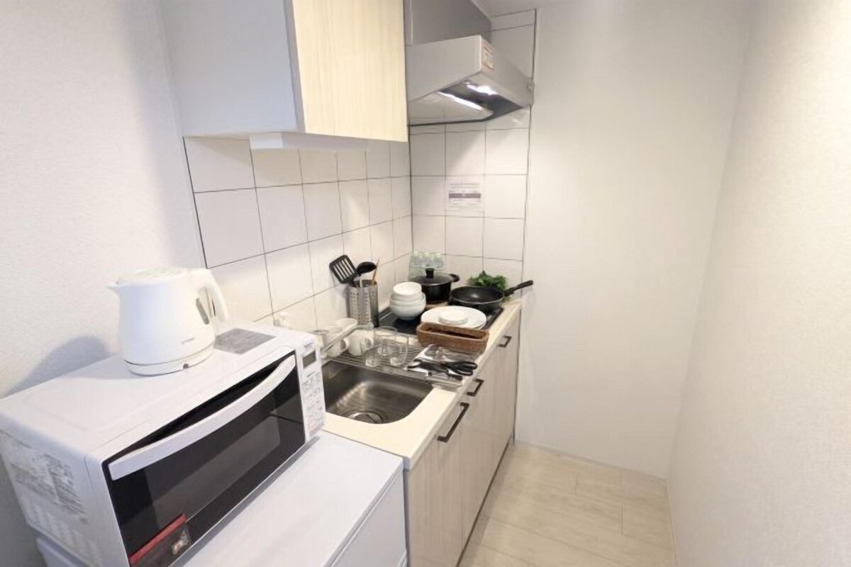 Uma cozinha compacta com micro-ondas, pia e fogão.