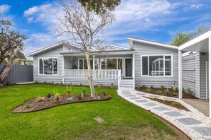 Two-story house with a covered porch and well-manicured lawn.