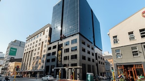 A modern building with a glass facade and a sign reading "Tokyo". - The Tokyo 003 (Cape Town)
