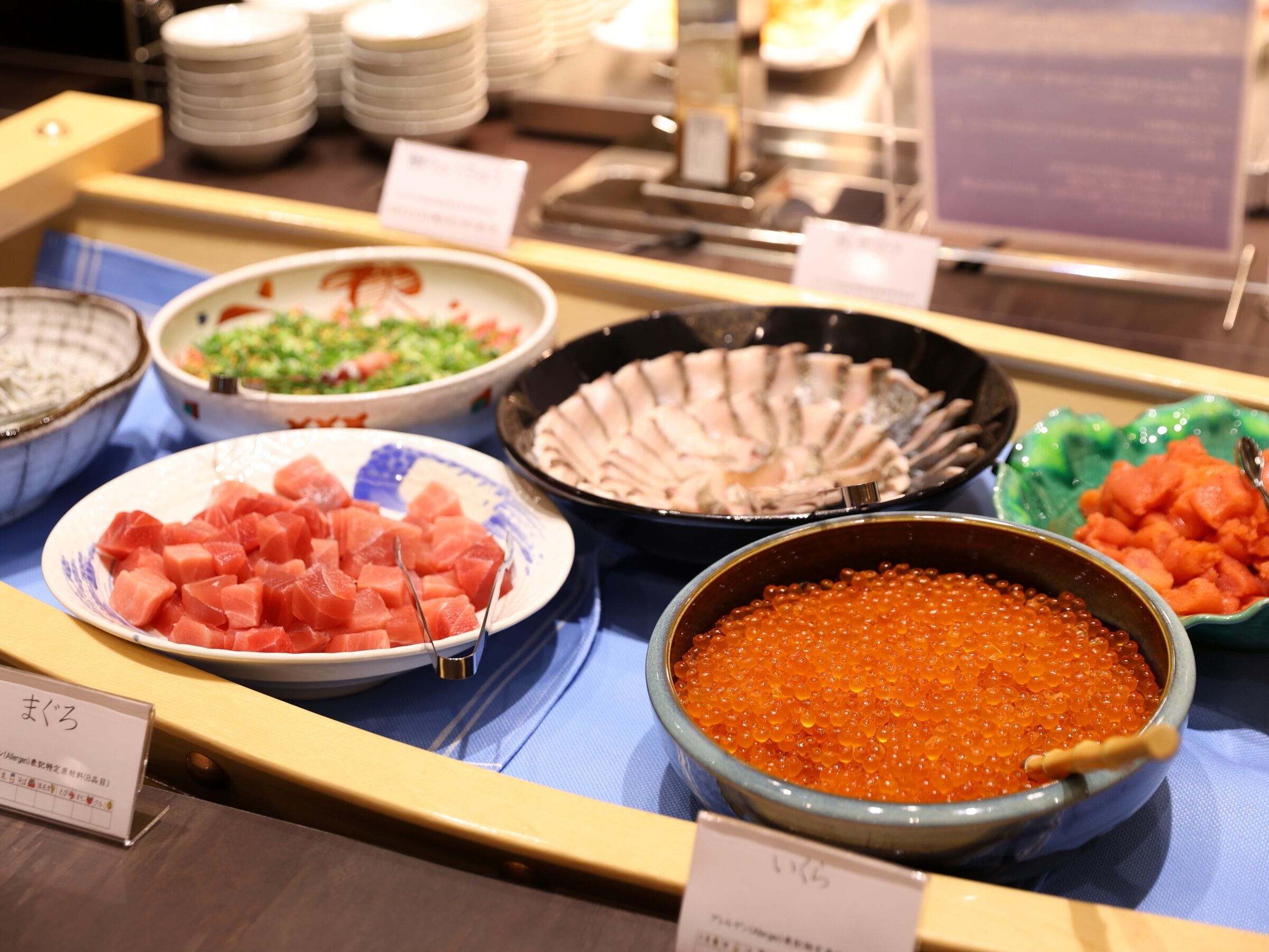 Un buffet proposant une variété de plats, notamment des sashimis, du caviar et d’autres fruits de mer.
