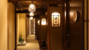 Un couloir japonais traditionnel avec des tatamis, des portes en bois et des paravents shoji.