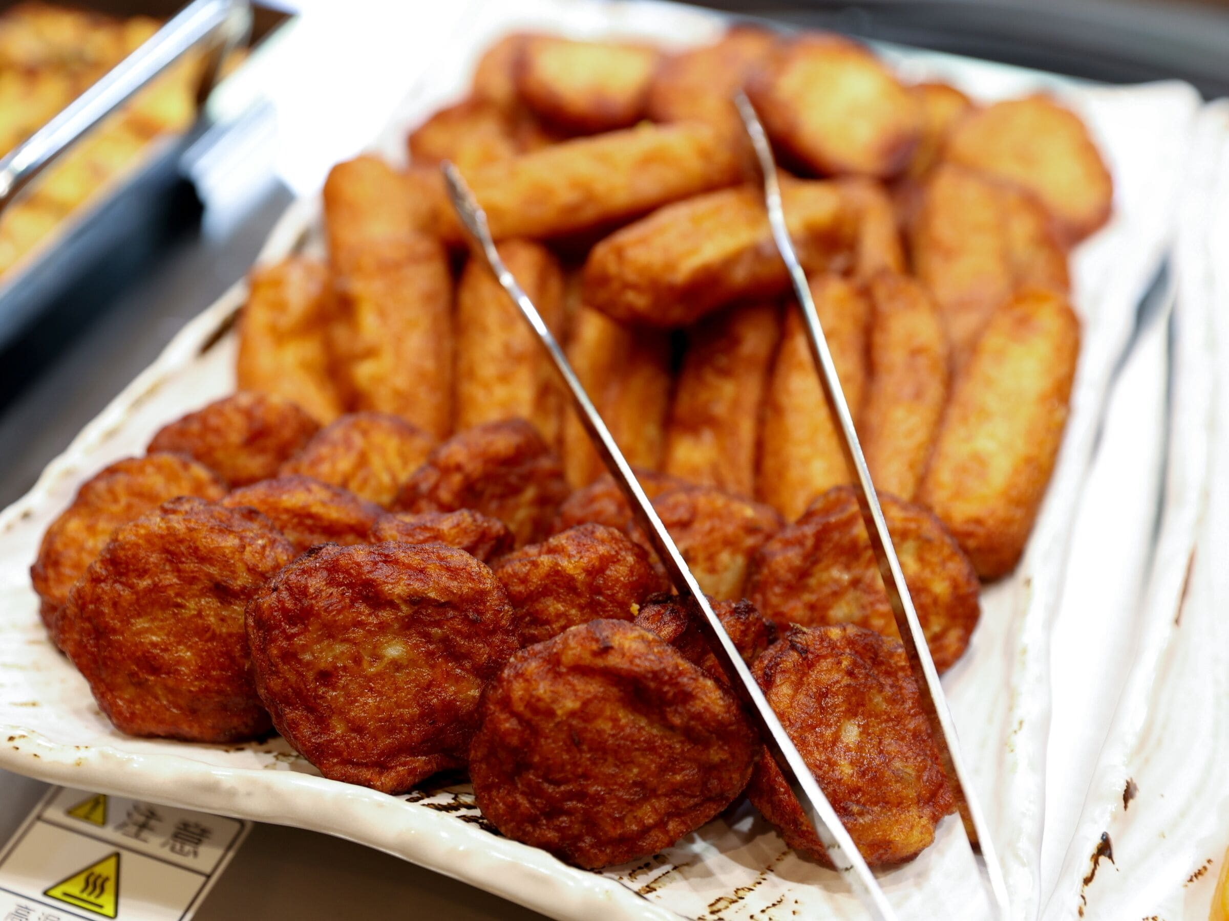 A plate of fried food items, including skewered and cylindrical shapes, likely a variety of snacks or appetizers.