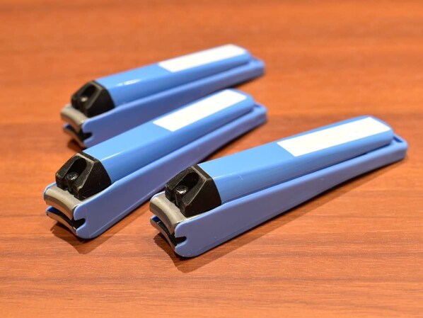 Three blue objects with black tops on a wooden surface.