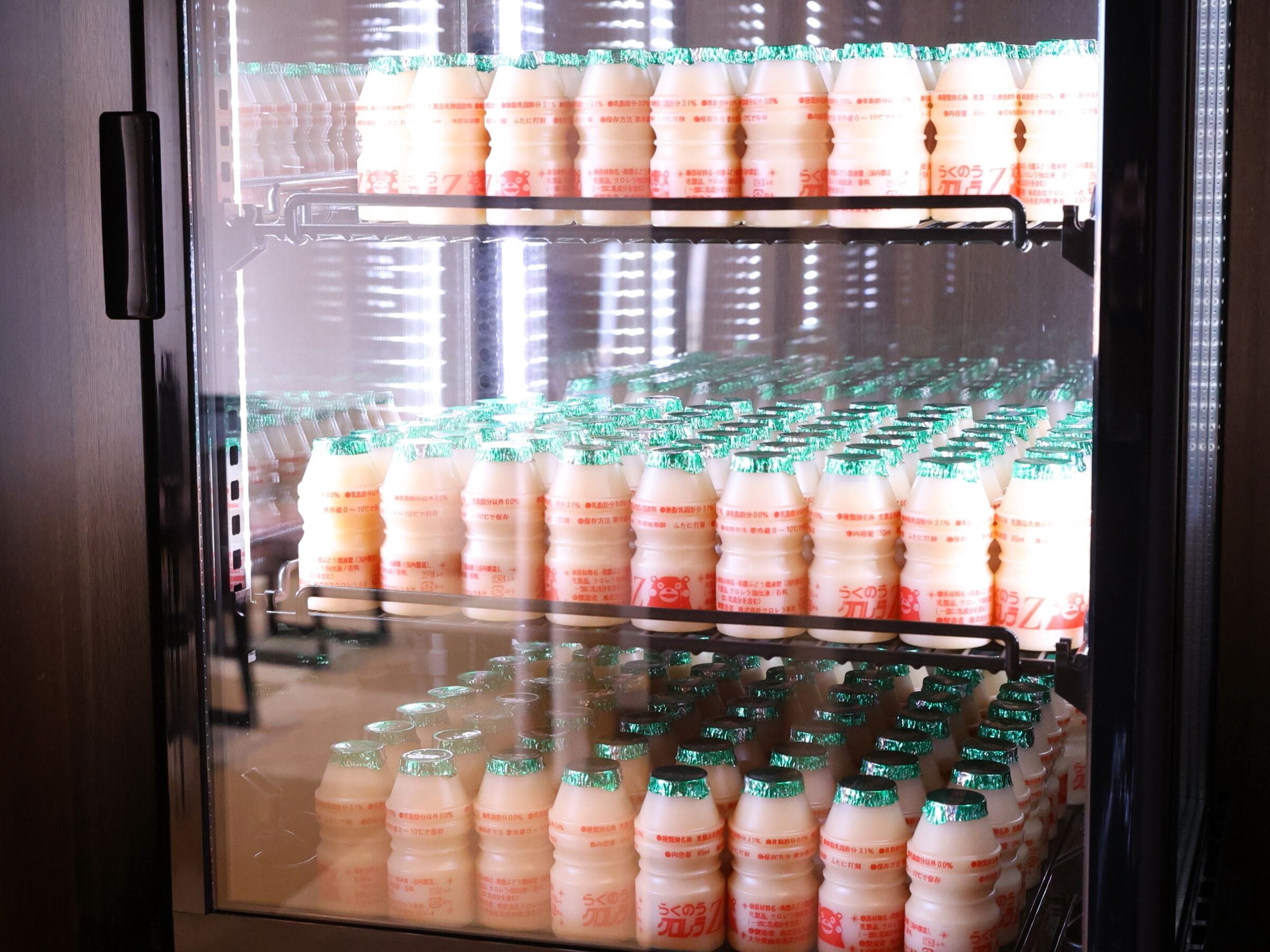 Un réfrigérateur-vitrine doté de plusieurs étagères pour présenter des boissons en bouteille.
