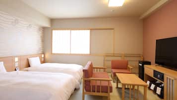 A hotel room with two beds, a TV, a desk, and a chair.