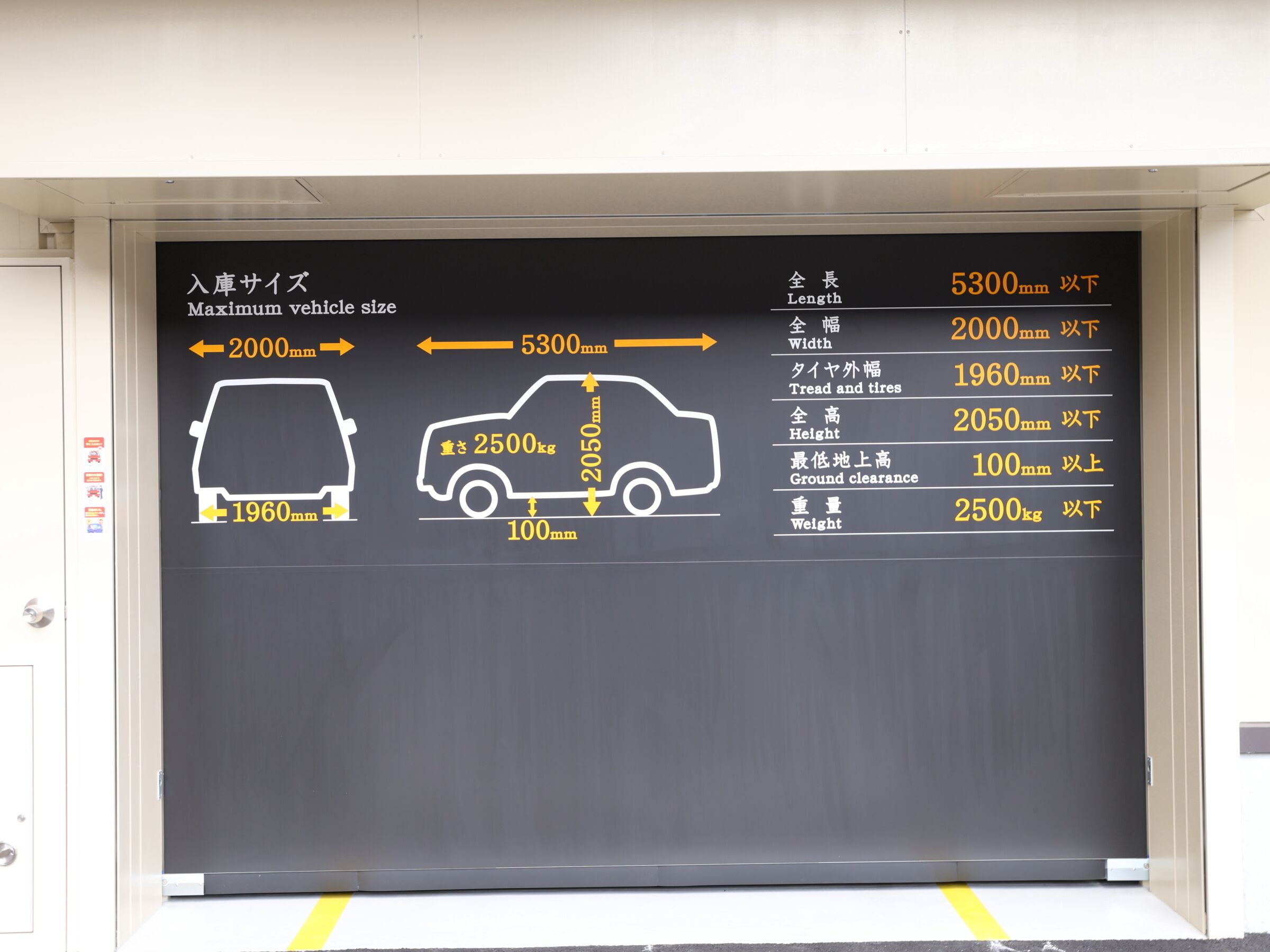 A blackboard with vehicle size and dimension guidelines in both Japanese and English.