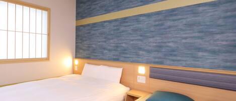 A hotel room with a bed, a bedside table, a nightstand, and a wall with a textured design.