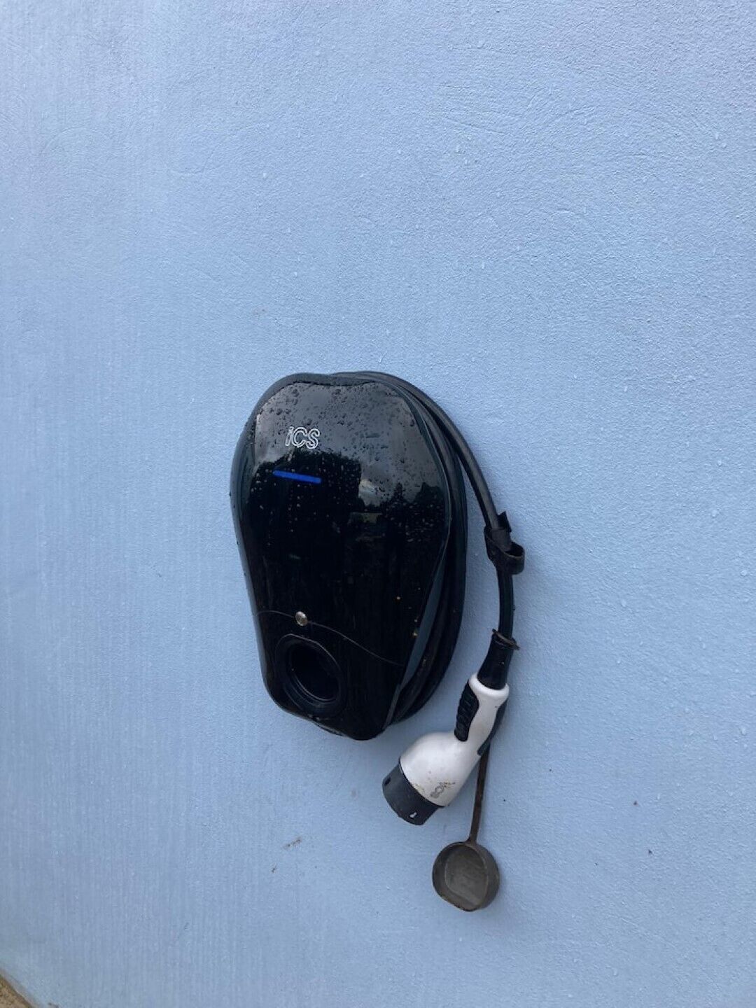 Un objet noir doté d’un manche blanc et d’une pelle métallique, le tout fixé à un mur.