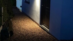 Een modern gebouw met een grindpad en een zwarte deur.
