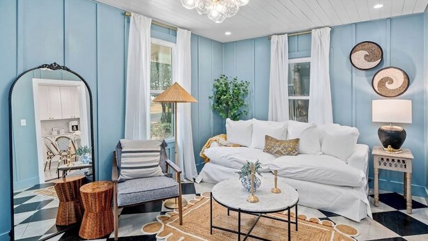 Un salon comprenant un canapé, un fauteuil, une table basse et des objets de décoration.
