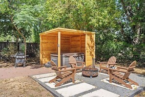 A wooden outdoor seating area with Adirondack chairs and a fire pit.