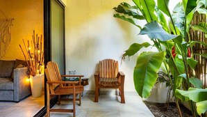 A cozy living area with a sofa, two wooden chairs, a small table, and a large plant. - MICAELA apartment, pool, AC next to the lagoon (Bárbara Guerrero Pérez)