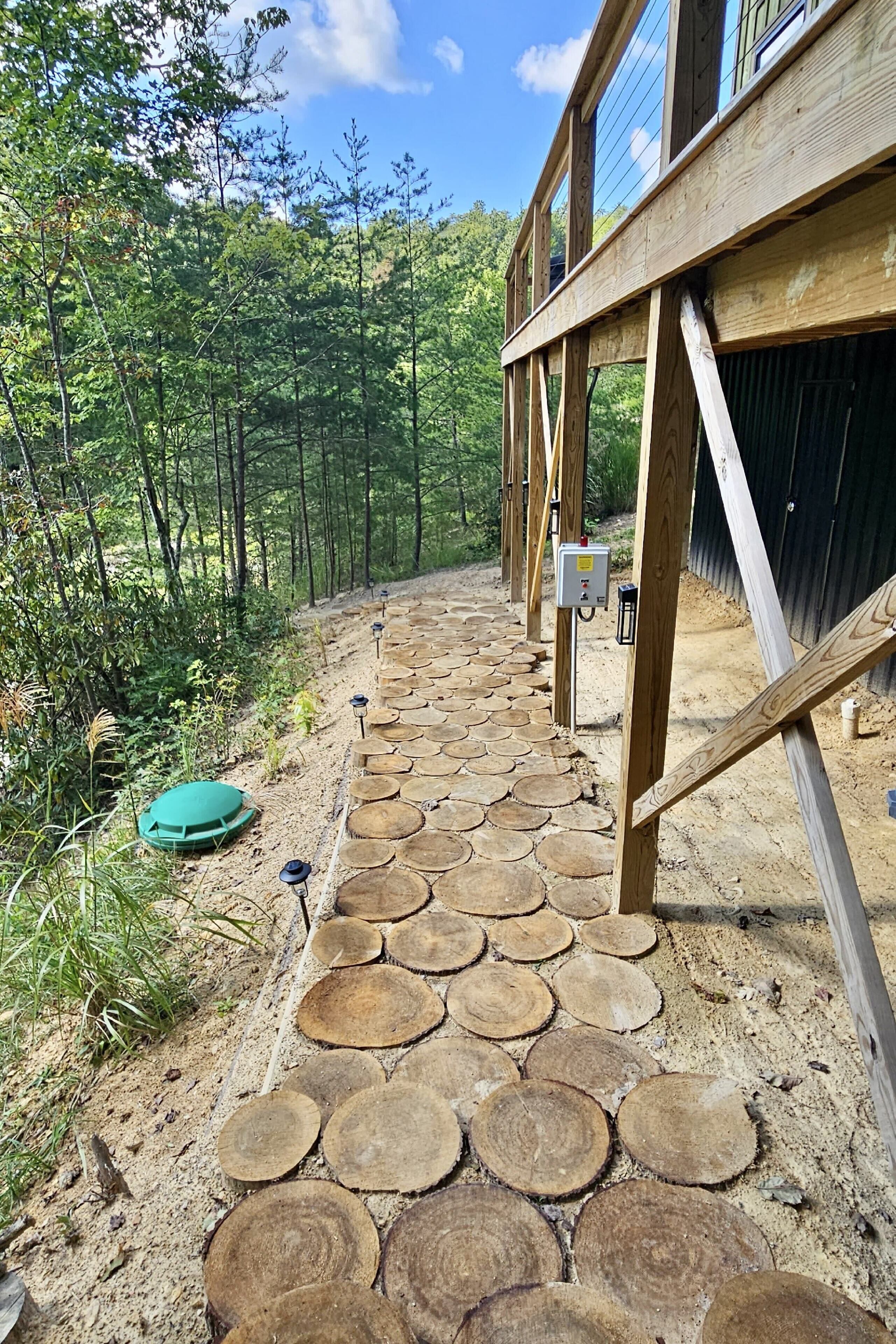 A wooden deck with circular cutouts leading to a building.