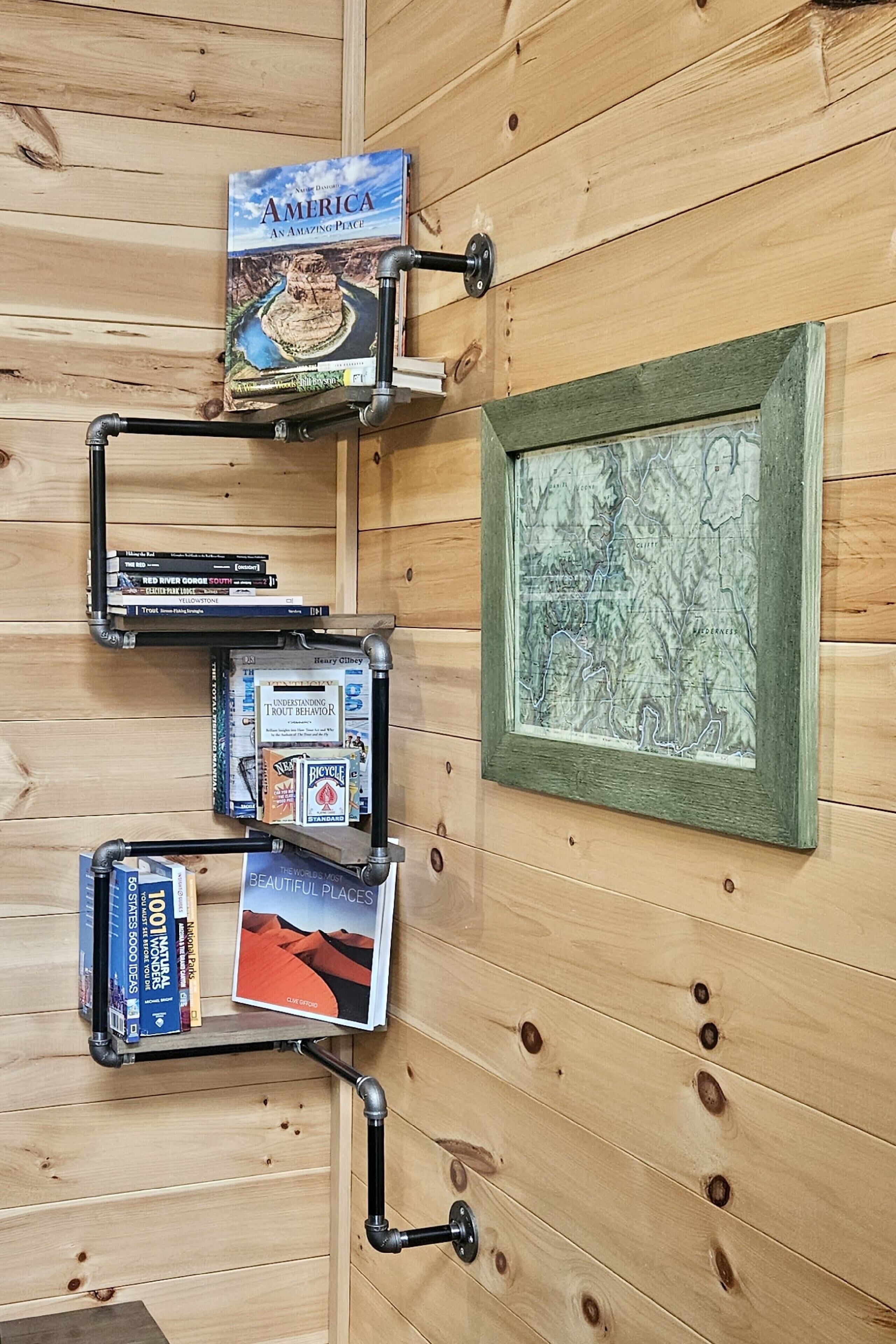 A wooden wall with a framed map and bookshelves with books.