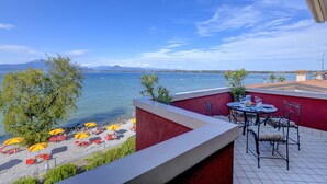 Eine Terrasse mit Meerblick, Sitzgelegenheiten im Freien und Sonnenschirmen.