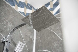 A showerhead with a square design, mounted on a curved arm, and a control panel with multiple buttons.