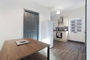 A modern kitchen with a built-in oven, a refrigerator, and a window with a view.