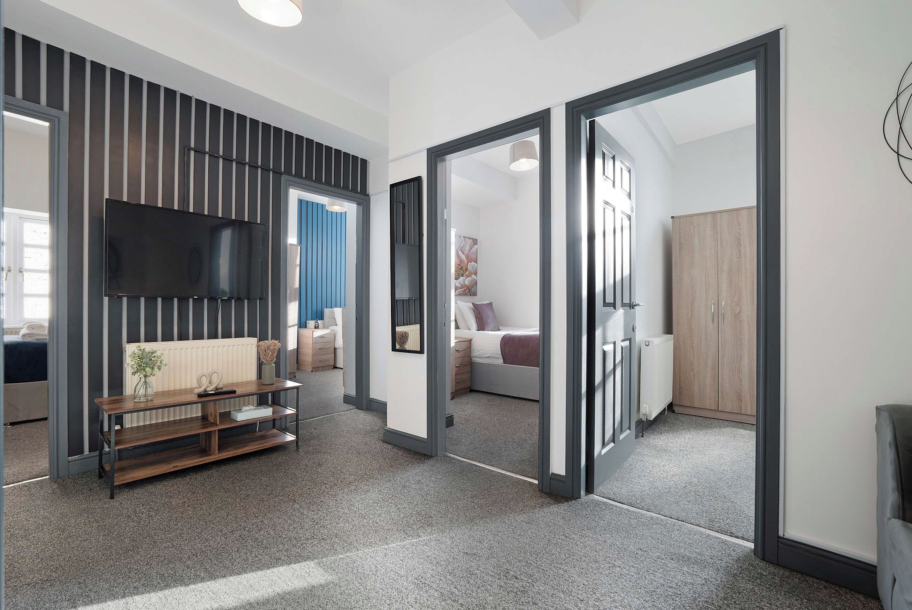 Relax in the comfortable living room, with a sofa and TV creating an inviting space to unwind. Enjoy natural light throughout the room, or gather around the dining table to plan your day, share a meal or catch up together.