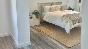 A bedroom with a bed, nightstand, and a floor lamp.