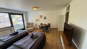 A room with two beds, a desk, a chair, a lamp, and a television. - Moderne Ferienwohnungen und -zimmer in Kleve (Kleve)