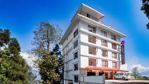 A multi-story building with a red-roofed entrance and a sign for 'SUMITE PELLING'. - Sumitel Pelling (Gyalshing)