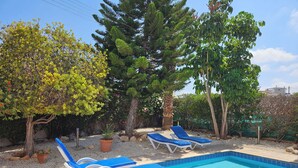 A swimming pool with lounge chairs and potted plants. - Gracelands Emba Cypriot Village Life (Emba)