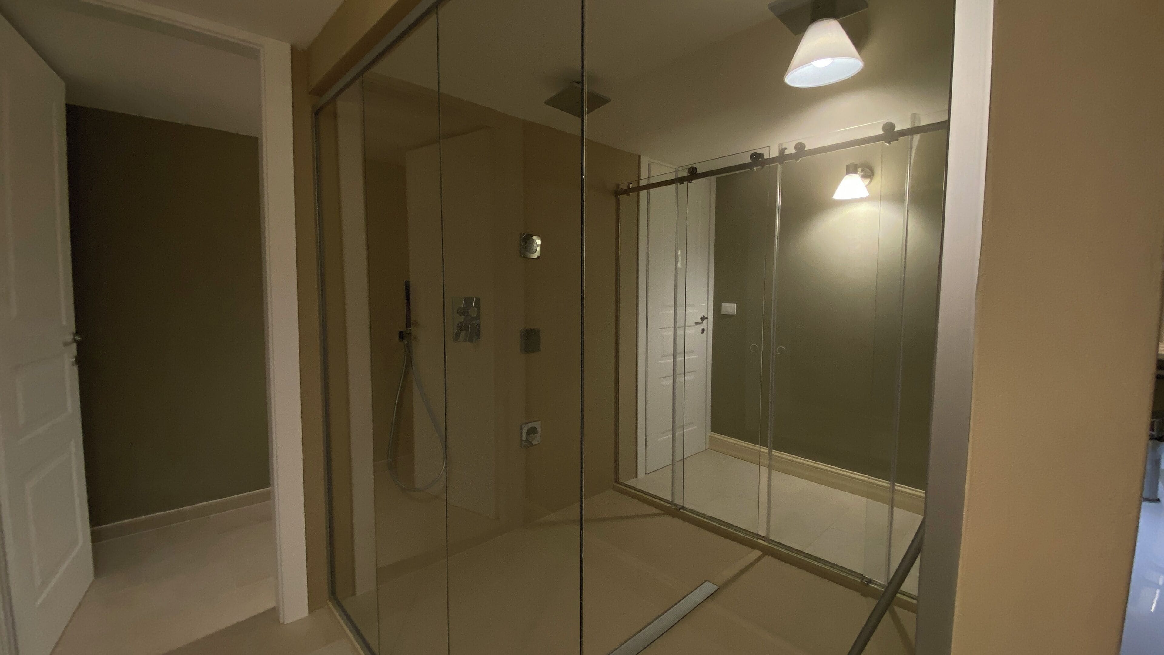 A modern bathroom with a glass shower enclosure, a toilet, and a sink.