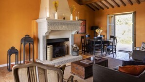 Una sala de estar acogedora con chimenea, un comedor y vistas al exterior.