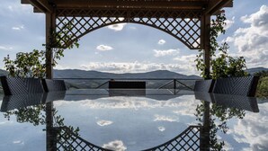 Un mirador techado con vistas despejadas a un lago y montañas al fondo.