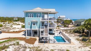 A multi-story beachfront property with a pool, balconies, and a covered patio. - Welcome to Rock Lobster! (St. George Island)