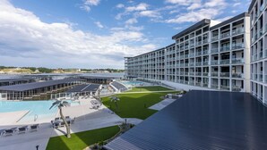 A modern hotel with a large pool area, multiple balconies, and a view of the surrounding landscape. - Topsider Experience in the Heart of Osage Beach (Osage Beach)
