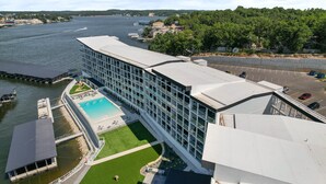 A modern hotel with a swimming pool, a view of the river, and a parking area. - Topsider Experience in the Heart of Osage Beach (Osage Beach)