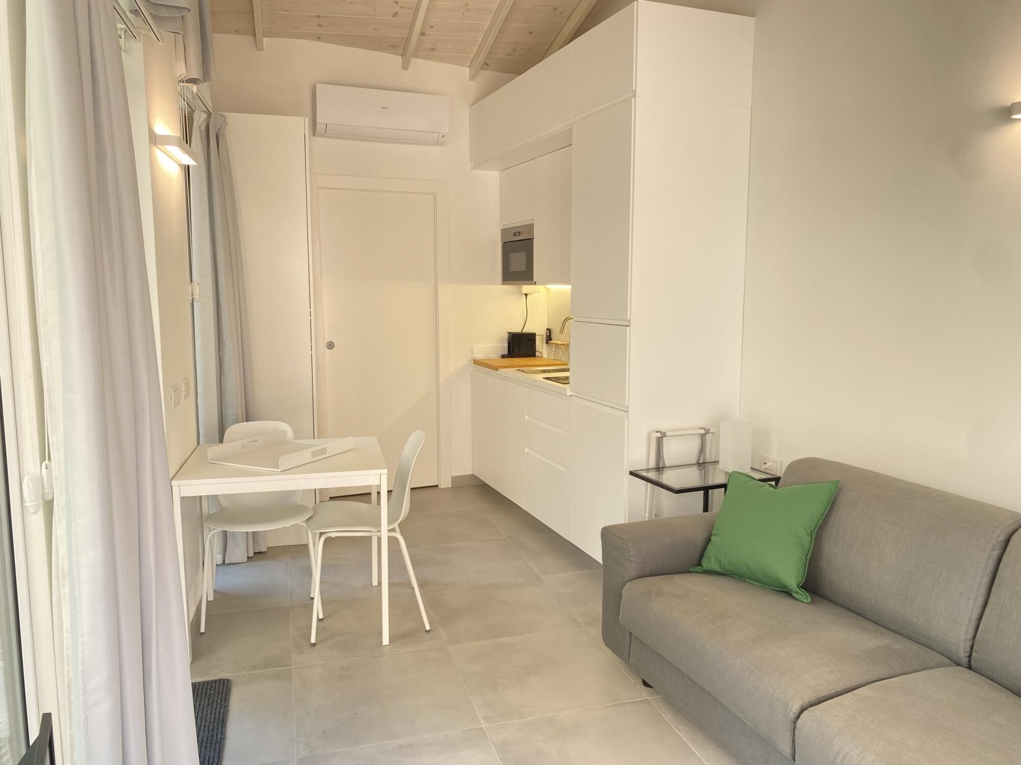 A compact living space with a kitchenette, a dining area, and a seating area.