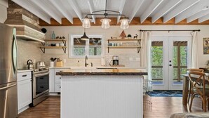 Eine moderne Küche mit Kochinsel, Edelstahlgeräten und Holzboden.