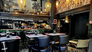 A bar area with multiple seating options, including tables and chairs, and a patterned wall decoration. - Hôtel La Pièce  (Brussels)