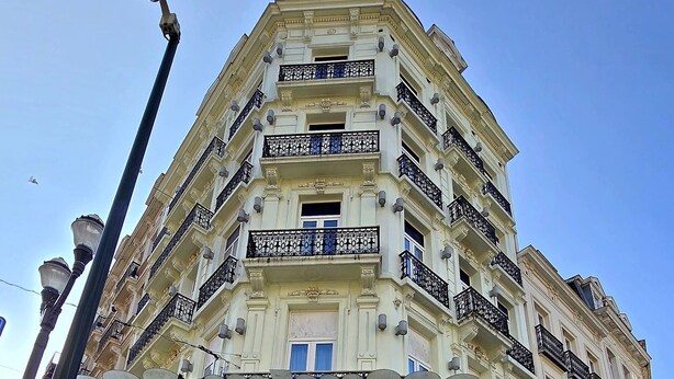 A multi-story building with a covered entrance and a sign for 'PIECE Cafe-Resto-Bar'. - Hôtel La Pièce  (Brussels)